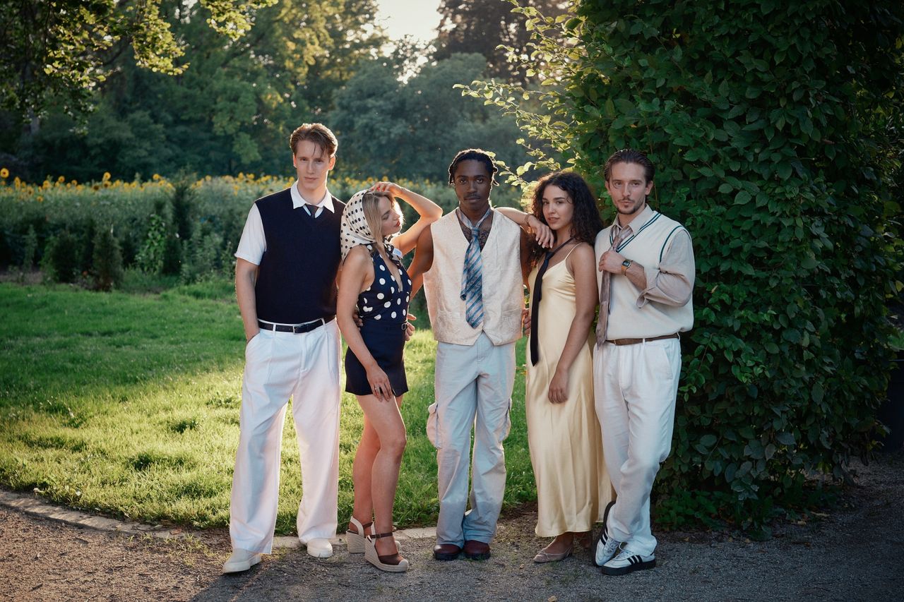 About Five stylish young adults posing in a summer park, exuding modern fashion and confidence.