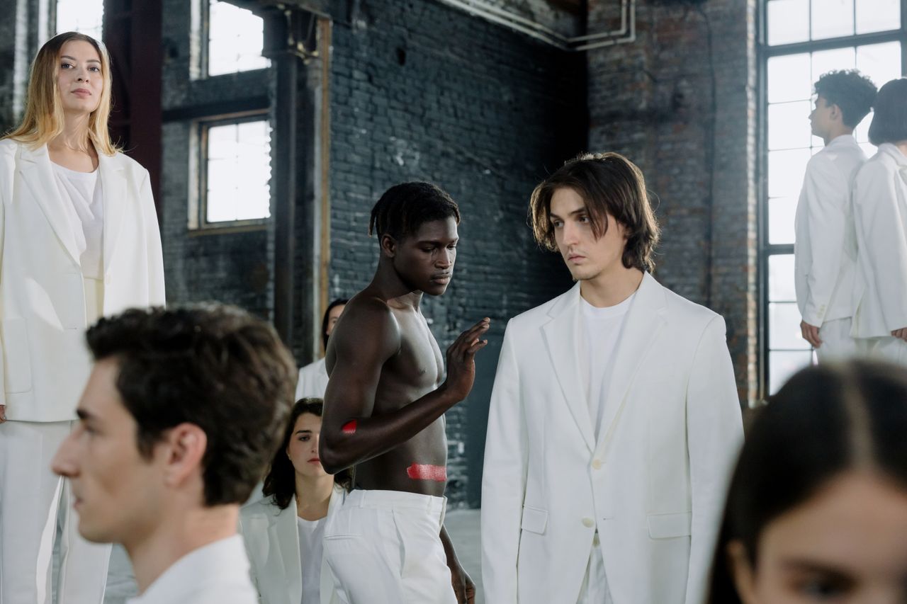 About Models in a fashion shoot wearing white outfits in an industrial space.